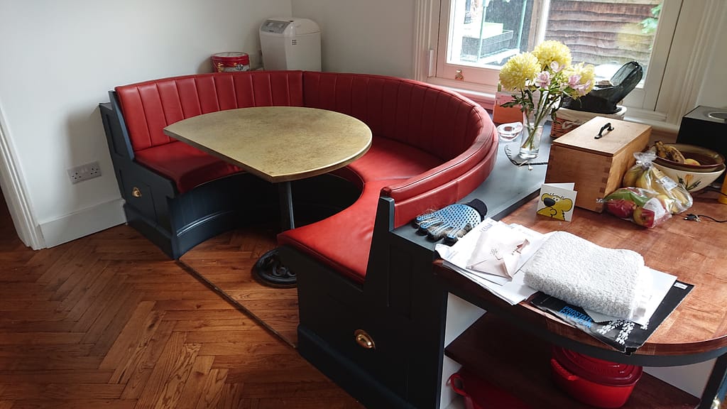 D-Shaped Brass Table – Custom Booth Seating - Designs 05 D-end brass table paired with snug semi-circular red bench seating