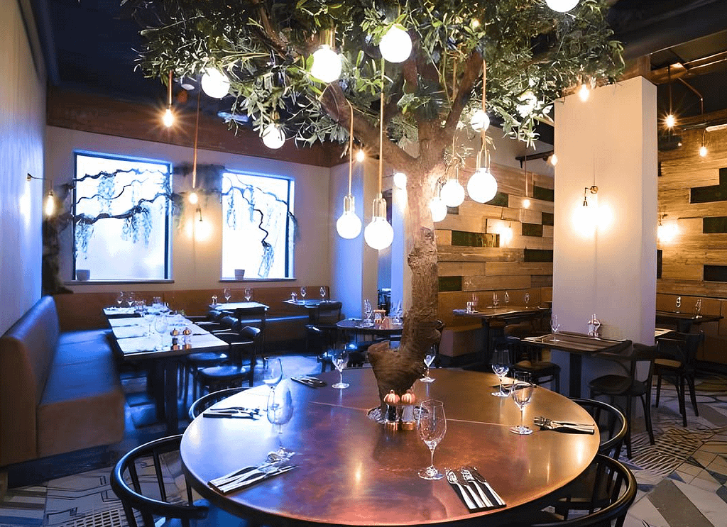 Olive-Tree-Copper-Table-Top - Designs 05 Round bespoke copper table top with tree feature in restaurant setting