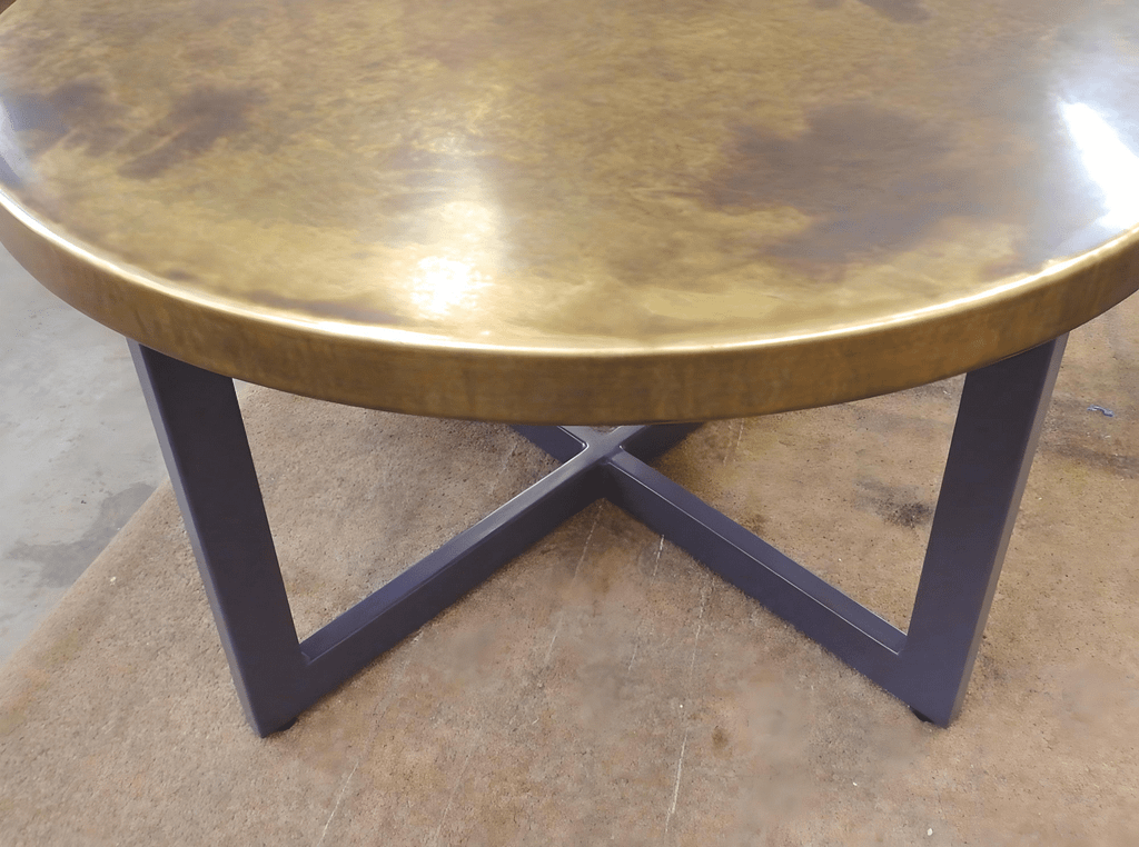 Aged Brass Round Table – Industrial Chic Design - Designs 05 Round aged brass table with a natural patina, mounted on a black metal base, designed for industrial and rustic interiors