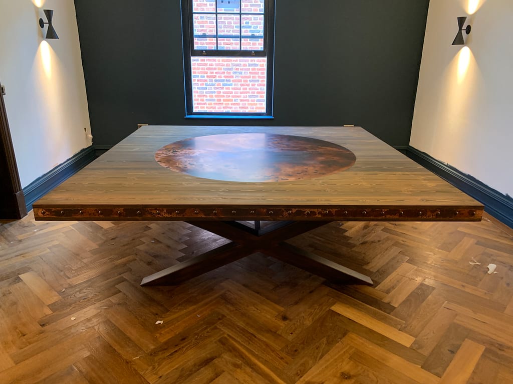 Timber Table with Aged Copper Inlay and Bronze Studs Timber table top featuring an aged copper inlay with domed bronze studs