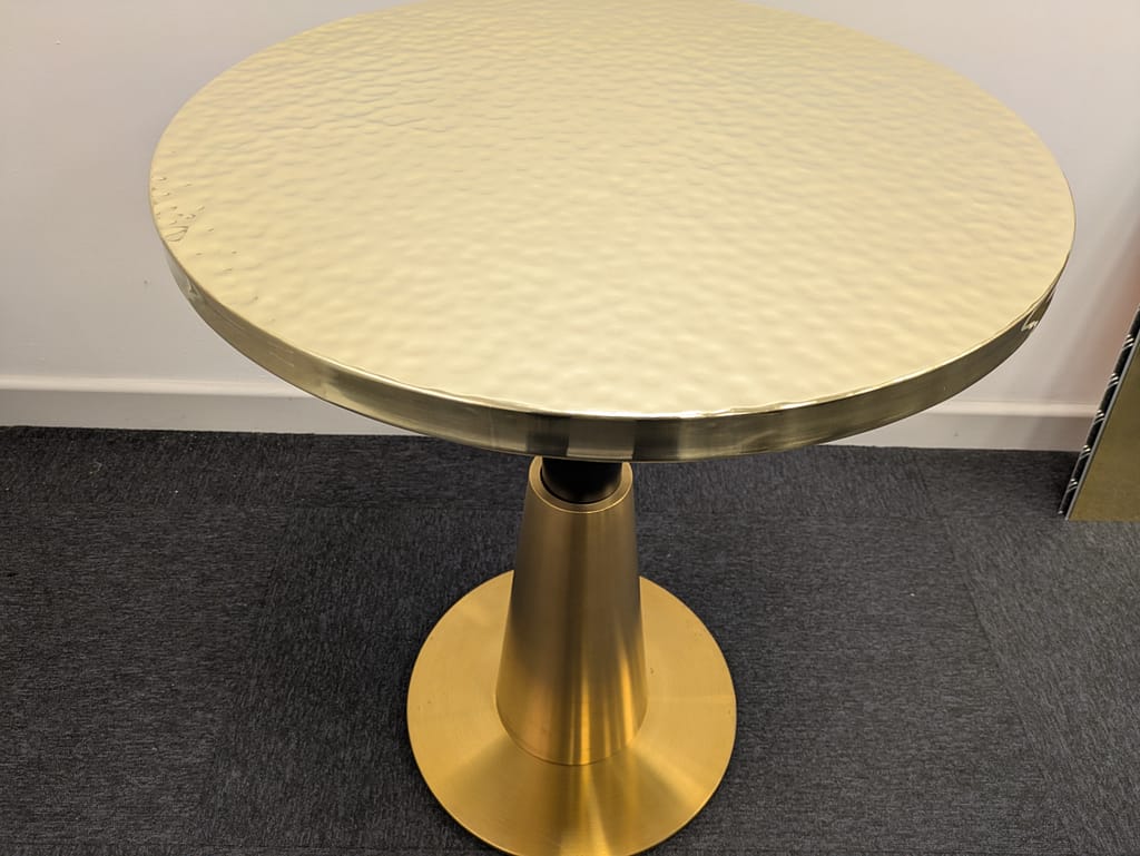 Hammered Copper Coffee Table – 65cm Round - Designs 05 Hammered brass coffee table top with a handcrafted textured finish, ideal for lounges and boutique cafés.