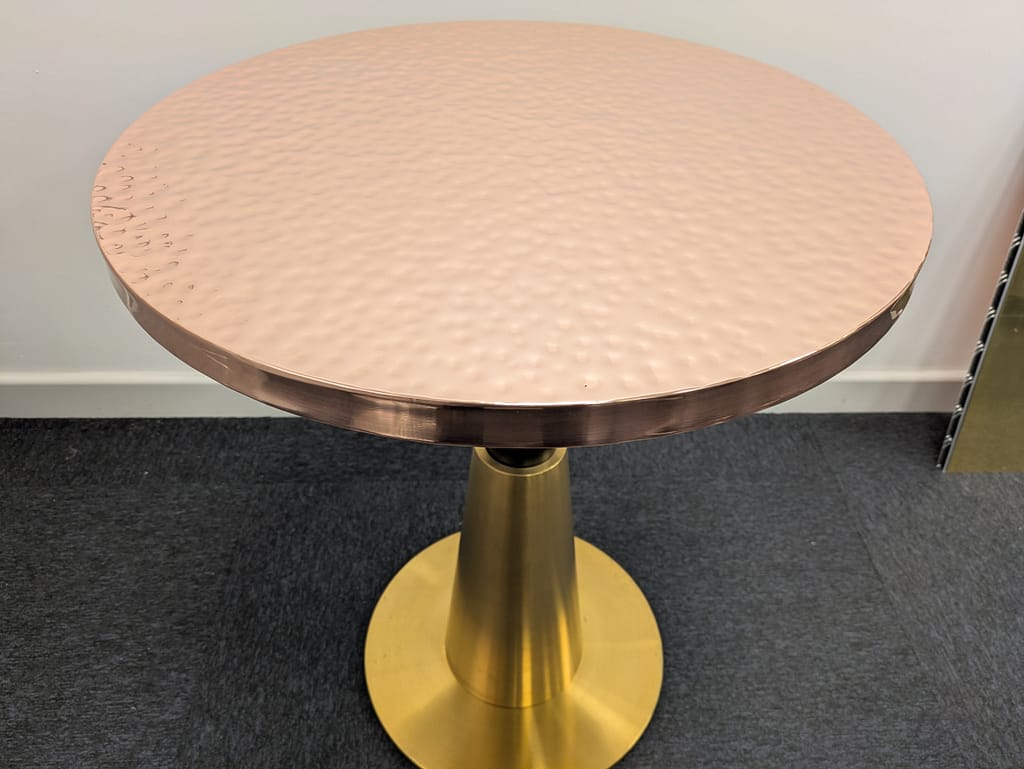 Hammered Copper Restaurant Table – 65cm Diameter - Designs 05 Hammered copper restaurant table top with a warm metallic sheen, designed for hospitality and fine dining spaces.