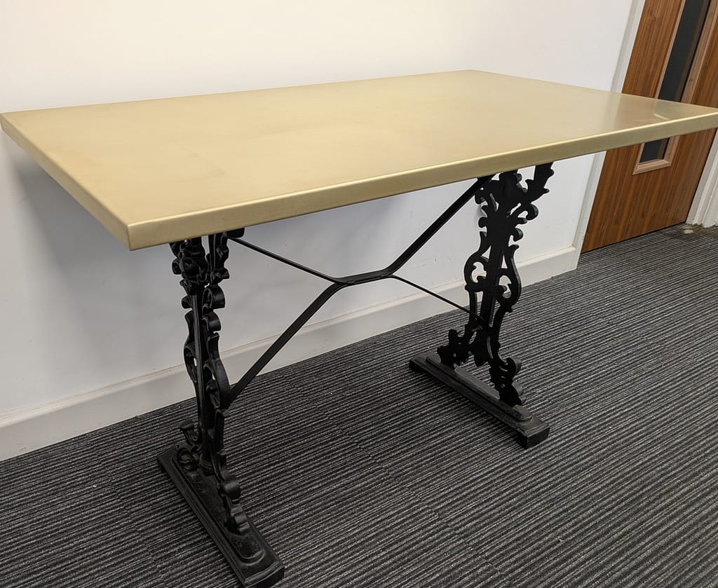 Classic Brass Table with Cast Iron Base – Timeless Elegance - Designs 05 Rectangular brass table top with a smooth satin finish, paired with an ornate black cast iron base for a vintage-inspired look