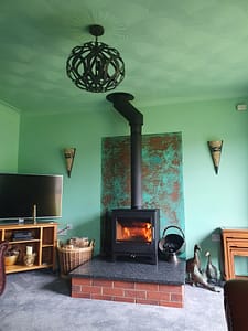 Green-Copper-Wall-Art - Designs 05 A green copper panel in a living room behind a stove
